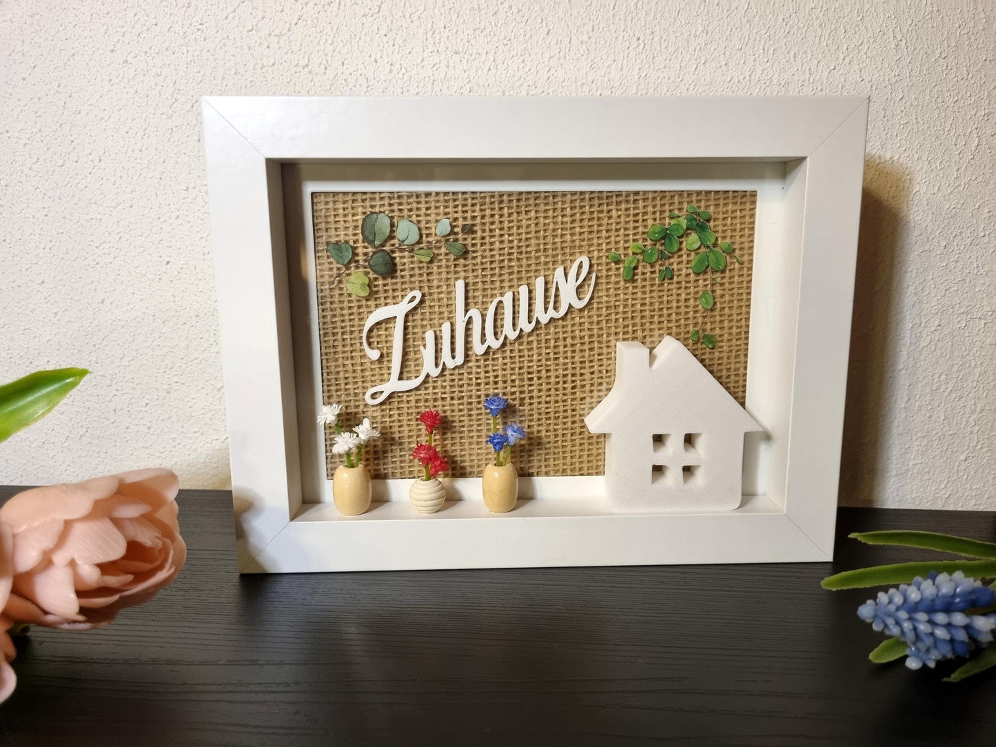 Detailansicht rustikale Holzrahmen-Deko mit 3D-gedrucktem Häuschen und Holzperlen-Vasen
