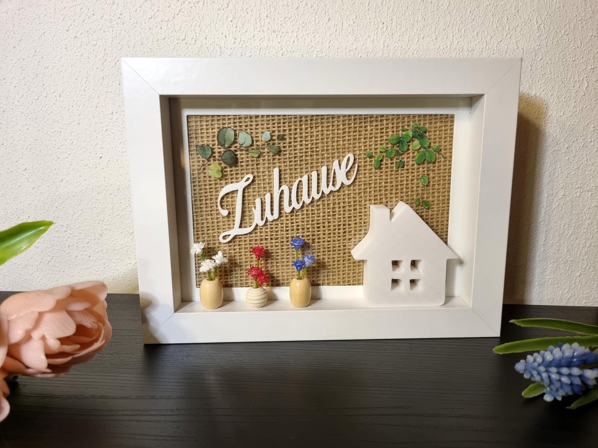 Detailansicht rustikale Holzrahmen-Deko mit 3D-gedrucktem Häuschen und Holzperlen-Vasen
