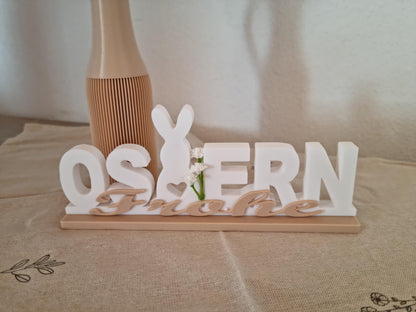 Nahaufnahme 'Frohe Ostern' mit weißen Kunstblumen - Osterdekoration